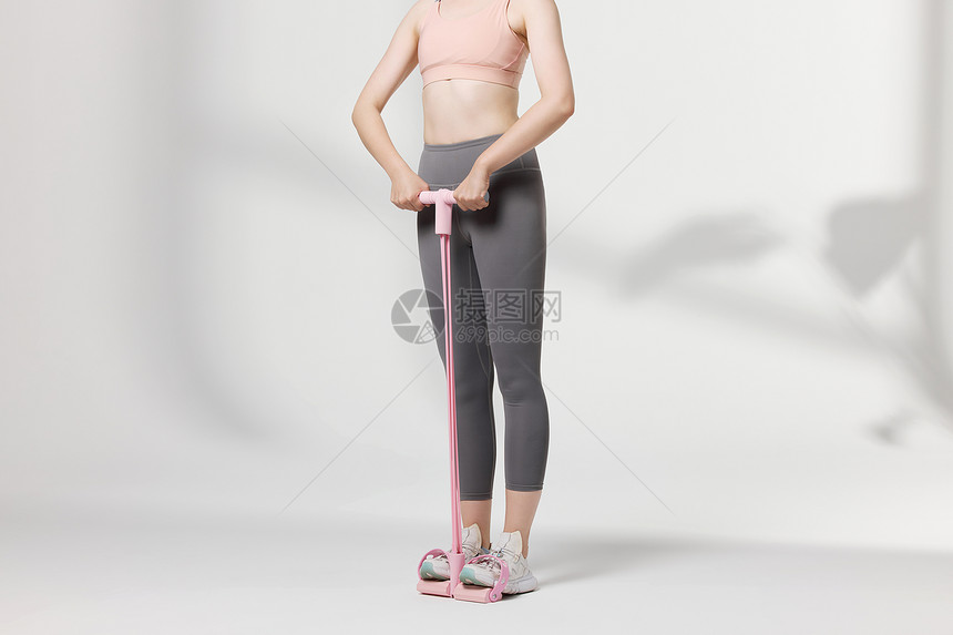 运动女性使用瘦身器材展示动作图片