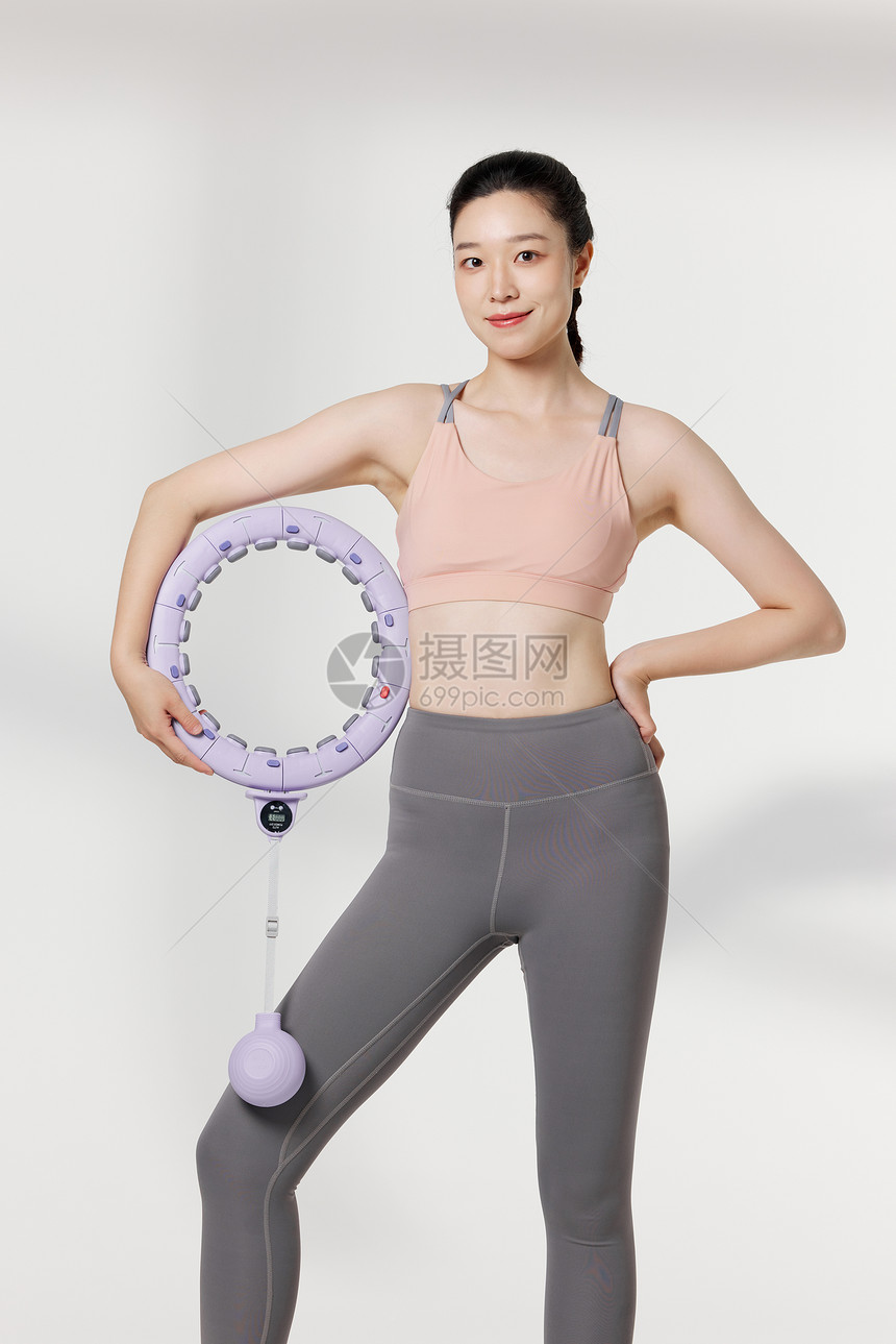 使用便携呼啦圈瘦身器材的健身女性图片