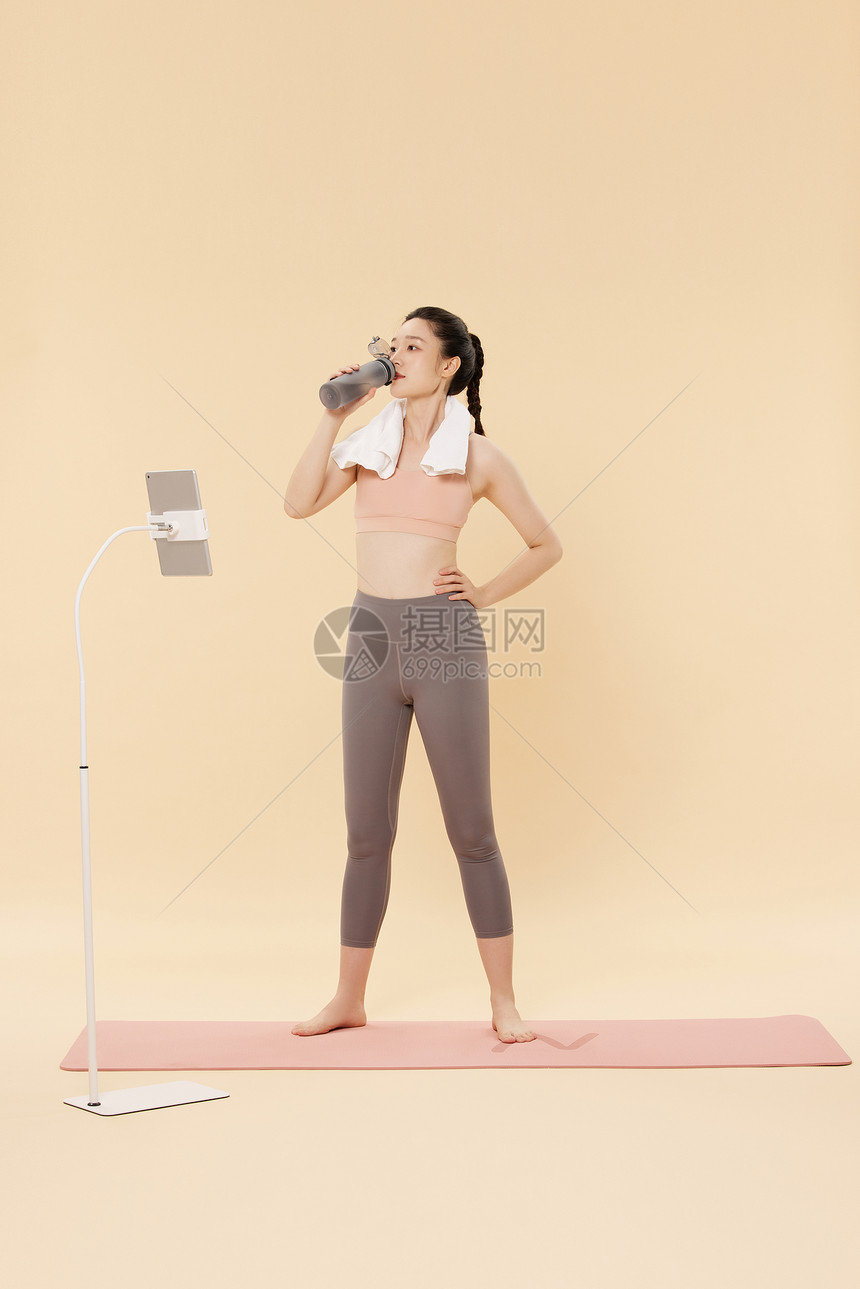 进行直播锻炼教学的女性休息喝水图片