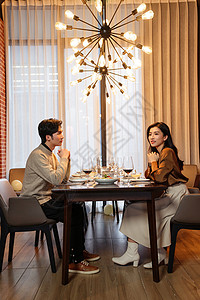 华丽地青年伴侣在餐厅用餐背景