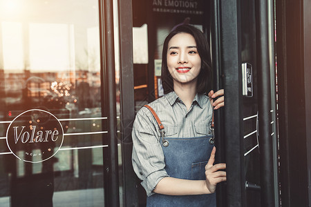 站在咖啡店门口的女服务员背景图片