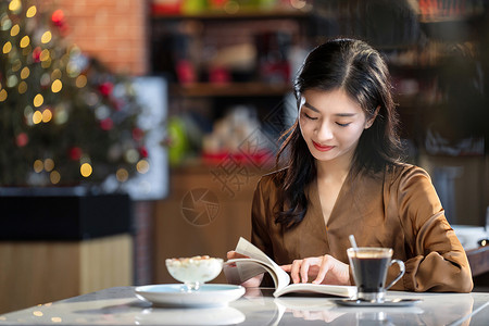 读书的乐趣咖啡馆内在看书的青年女人背景