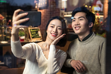 餐厅内的青年伴侣使用手机自拍高清图片