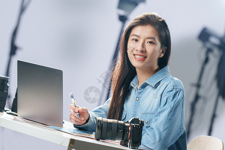 电子工艺在工作室里的青年女摄影师背景