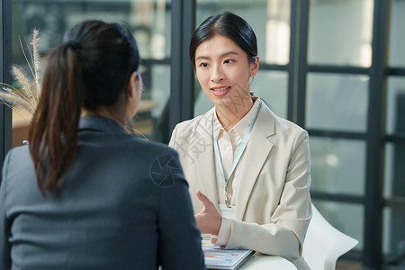 营销人员青年女设计师和顾客交谈背景