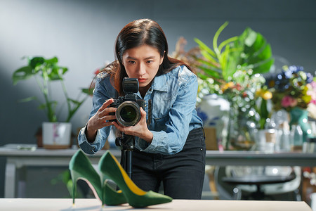 办公室花卉在工作室里拍照的青年女摄影师背景