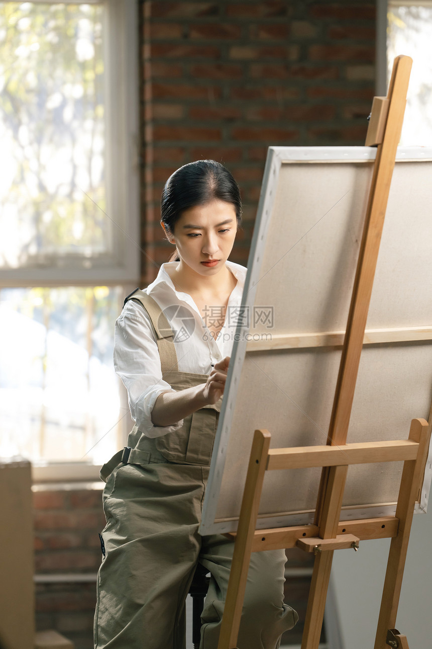 青年女画家在工作室里创作图片