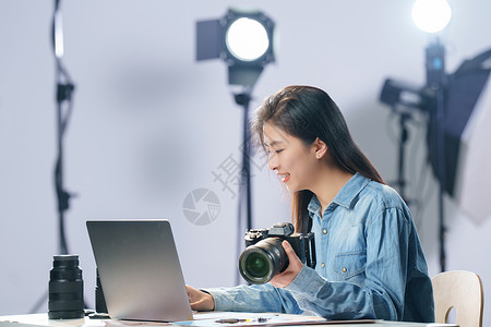 灯光器材在工作室里的青年女摄影师背景