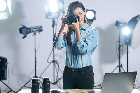 摄影公司单页在工作室里的青年女摄影师背景