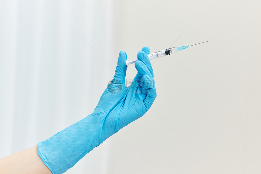医护人员手拿疫苗针管特写图片