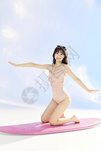 泳装美女跪在冲浪板上图片