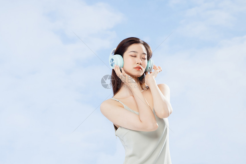 头戴耳机听音乐的夏季清凉美女图片
