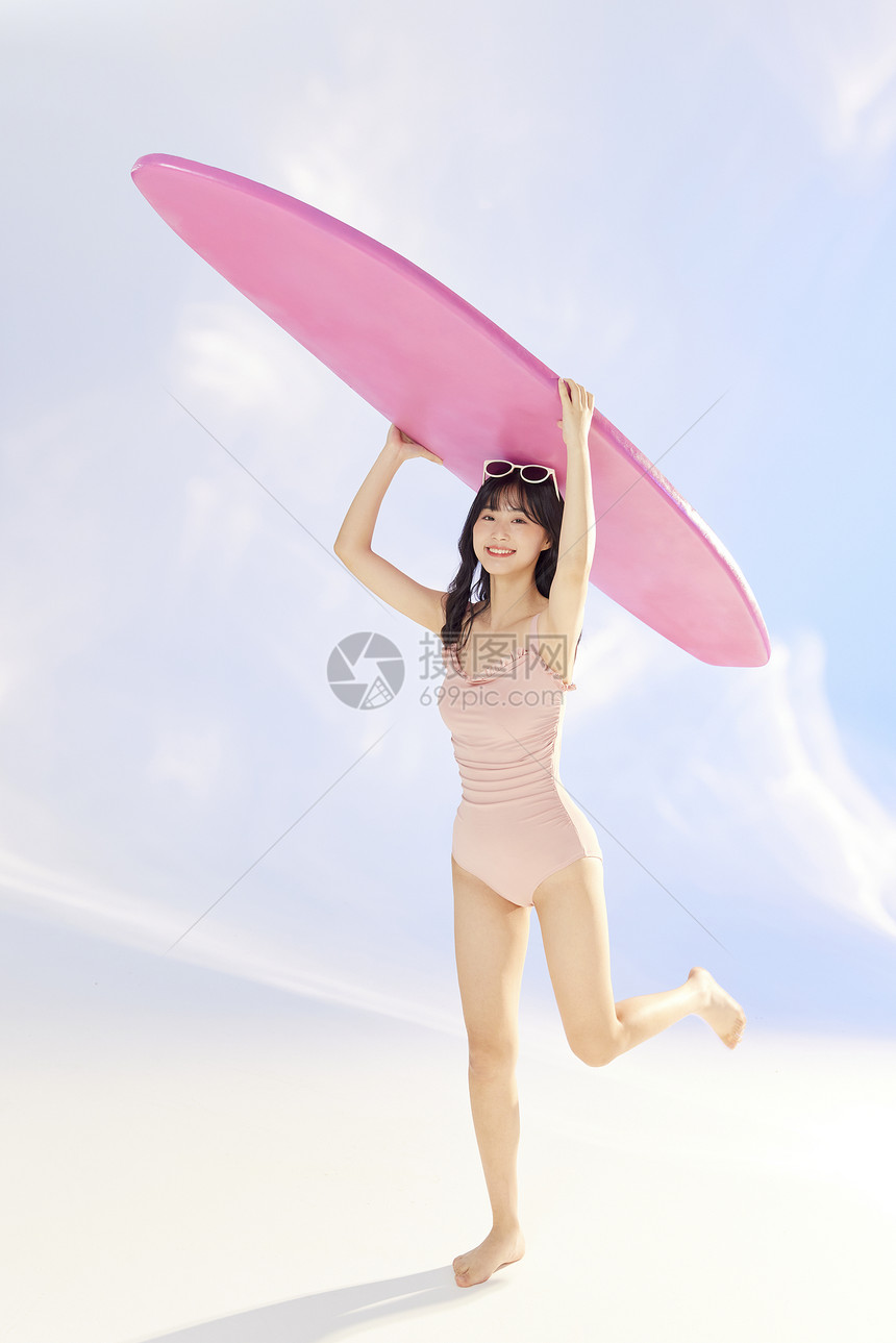 夏日泳装美女拿着冲浪板奔跑图片