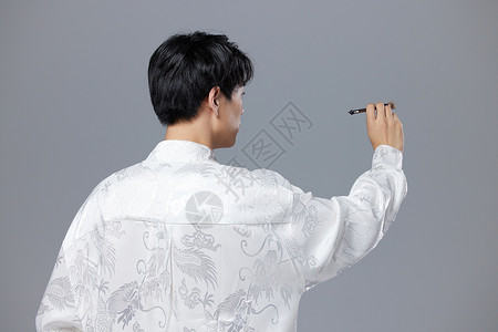 时尚风向毛笔字手拿毛笔书写的新中式少年背景