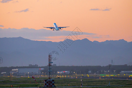 夕阳下机场起飞的飞机图片