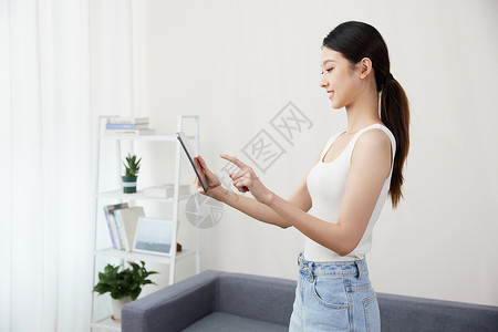 女性在家使用平板电脑背景图片