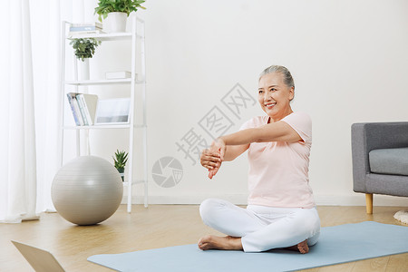 老年瑜伽在家里做伸展运动的老年人背景