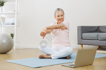 老年女性对着电脑学习瑜伽姿势图片