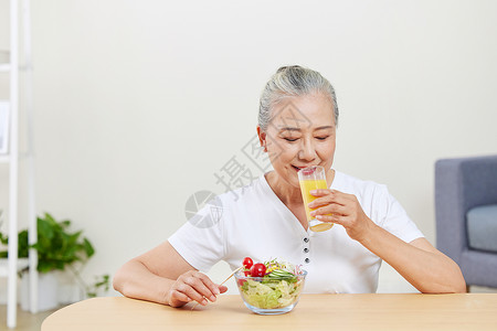 喝橙汁的老年女性图片