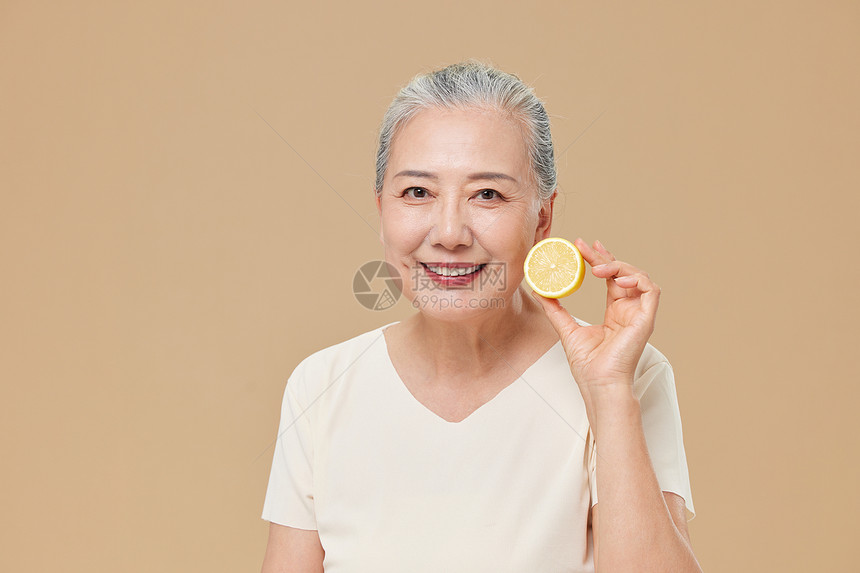 手拿柠檬展示的老年人图片