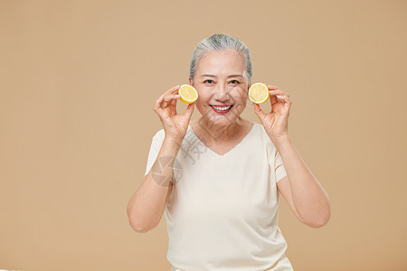 手拿柠檬的老年女性图片