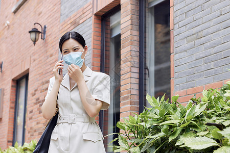 戴口罩的女白领室外打电话背景图片