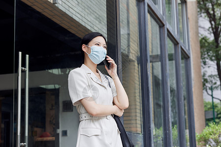 炎热室外戴口罩的商务女白领室外打电话背景