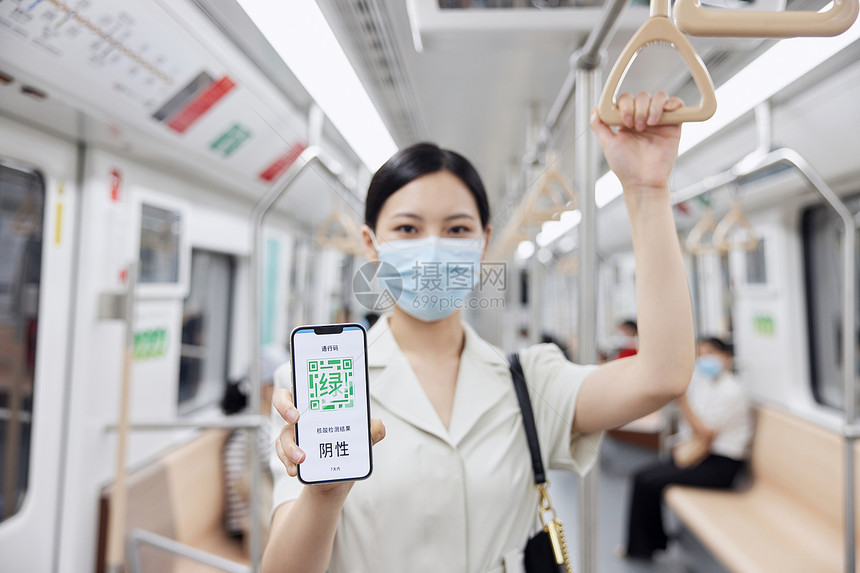乘坐轨道交通通勤的白领女性手持绿码图片