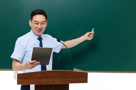 讲台上的老师中年男教授手拿平板电脑站在讲台上背景