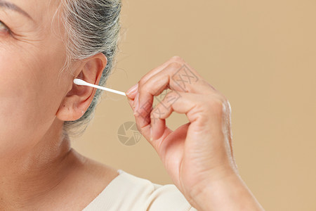 肌肤皱纹老年人使用棉签掏耳朵背景