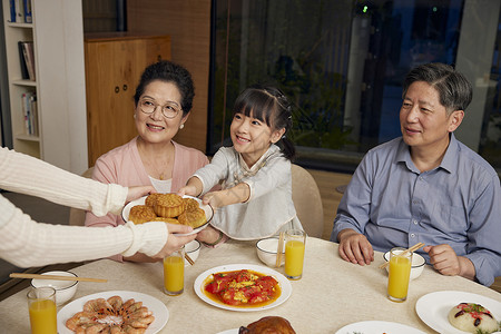 中秋节妈妈拿着月饼递给家人背景图片