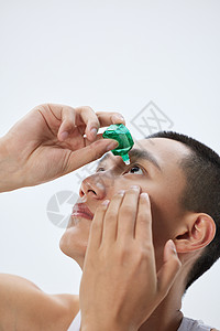 年轻男性使用眼药水护眼高清图片