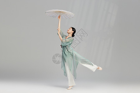 手拿油纸伞跳舞的传统东方美女背景图片