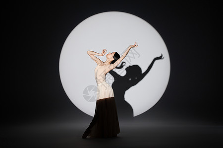 聚光灯前柔美起舞的女性舞者形象图片
