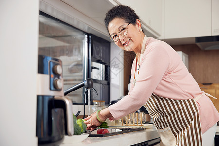 老年女性厨房洗菜形象背景图片