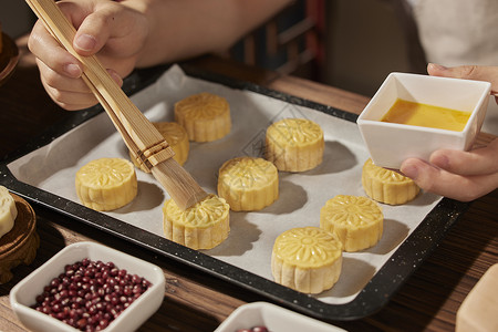 蛋黄白莲蓉月饼用刷子给月饼刷蛋液背景