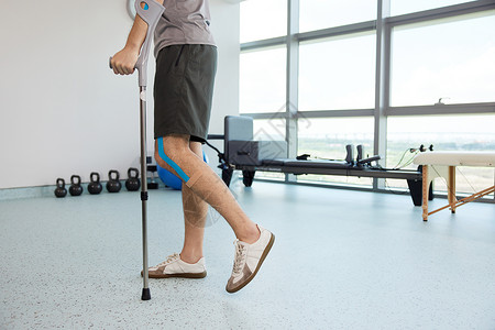 腿伤患者拄着拐杖背景图片