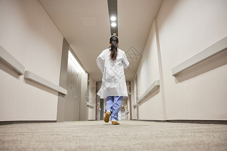 医院走廊女医生跑向手术室背影背景图片