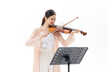 乐器演奏家看乐谱拉小提琴的青年女性背景