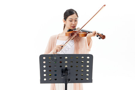 乐器演奏家看乐谱拉小提琴的青年女性背景