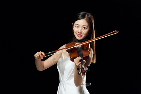 舞台上拉小提琴的优雅女性形象背景图片