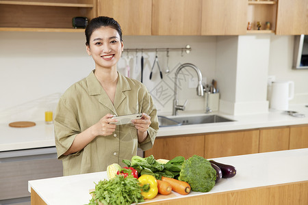 居家美女团购蔬菜拍照背景图片