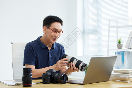中年男性在网络学习单反摄影知识背景图片