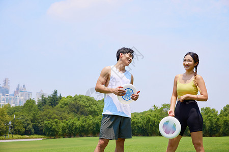 年轻男女在户外飞盘运动背景图片