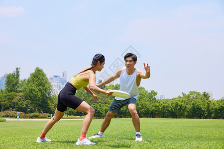 青年男女在户外玩飞盘高清图片