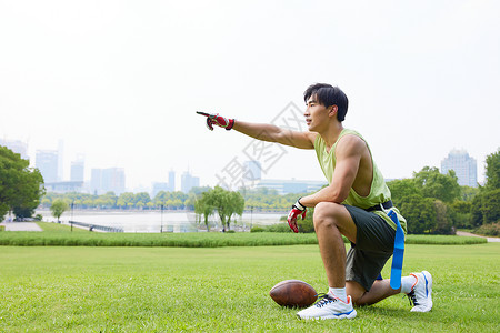 玩腰旗橄榄球指挥跑位的男青年背景