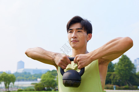 男青年户外草坪壶铃训练图片