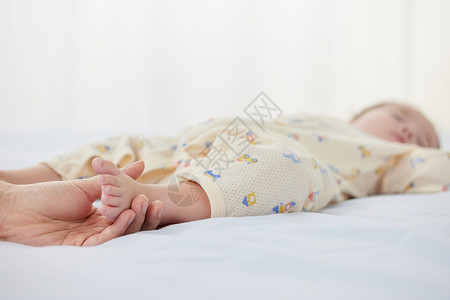 妈妈握着睡着的婴儿的脚图片