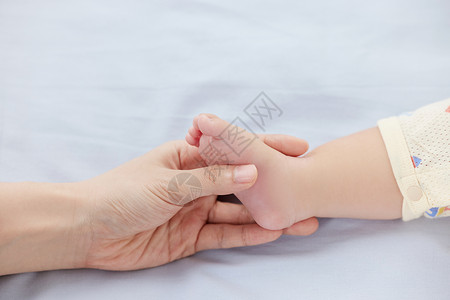 握着宝宝小脚的妈妈背景图片
