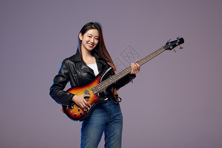 弹奏贝斯的摇滚女青年背景图片